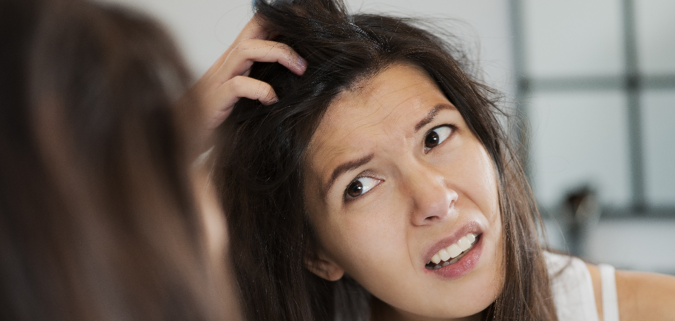 A woman scratching her scalp 