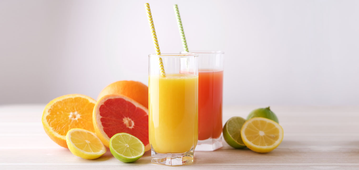 citrus fruits and fruit juices filled glasses