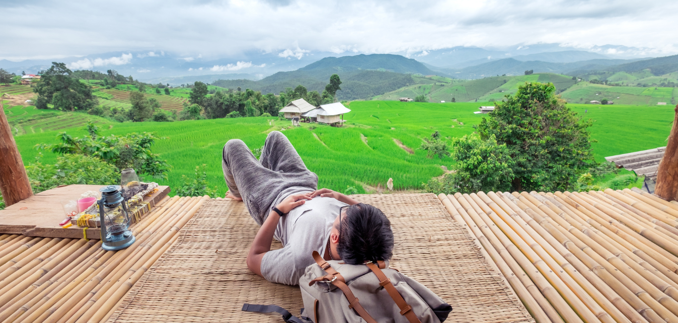 A man laying down and watching the scenery in a relaxed way