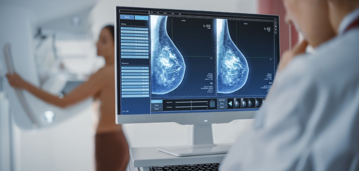 A doctor examining scans of an individual undergoing a screening test for breast cancer