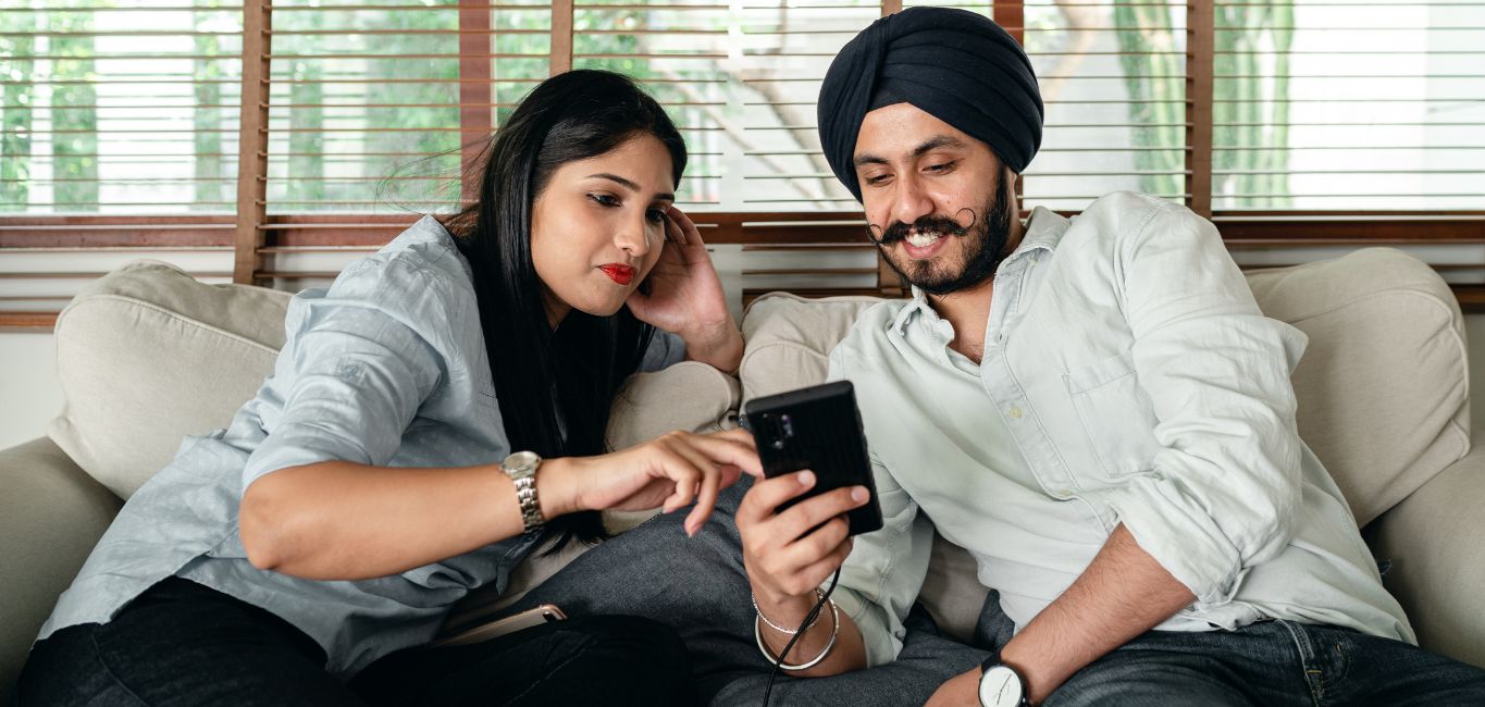 indian couple using phone, happy couple