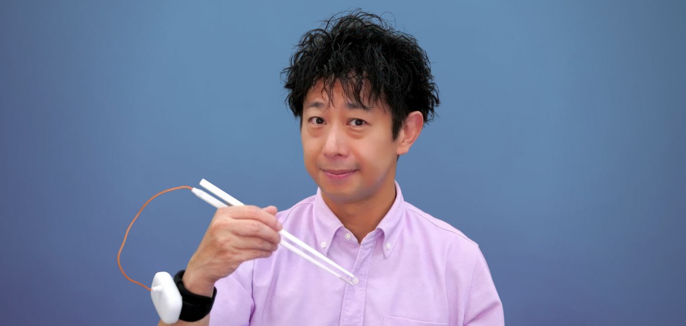 Inventor Homei Miyashita holding his electric chopsticks 